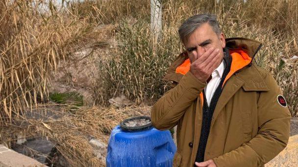 Mario Vadillo tapándose la nariz junto a un volcado cloacal contaminado en el canal Pescara, Mendoza