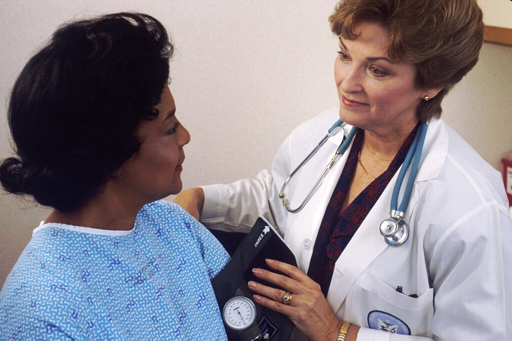 Médico tomando la presión arterial a un paciente adulto mayor