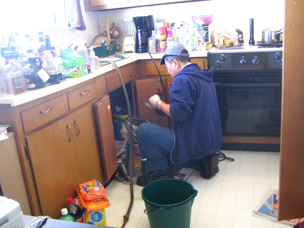 Plomero trabajando en reparación de cañería en vivienda alquilada