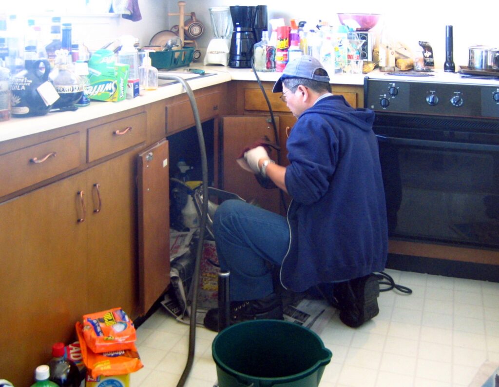 Plomero trabajando en reparación de cañería