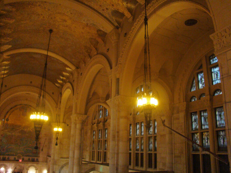 Interior neoclásico de banco con columnas y ventanillas