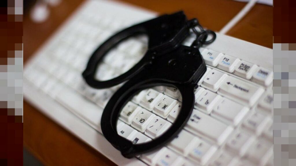 Teclado de computadora y esposas - estafa digital phishing correo electrónico ARCA