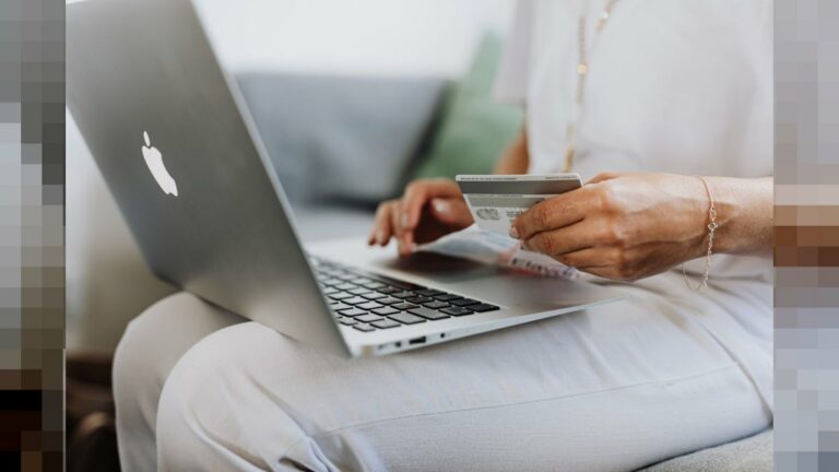 Persona sosteniendo tarjeta de crédito frente a laptop - e-skimming fraude compra online Argentina